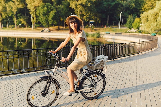 Junge Frau gegen Naturhintergrund mit Fahrrad