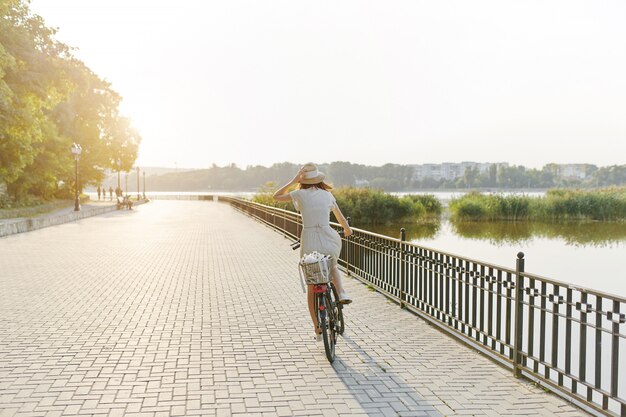 Junge Frau gegen Naturhintergrund mit Fahrrad