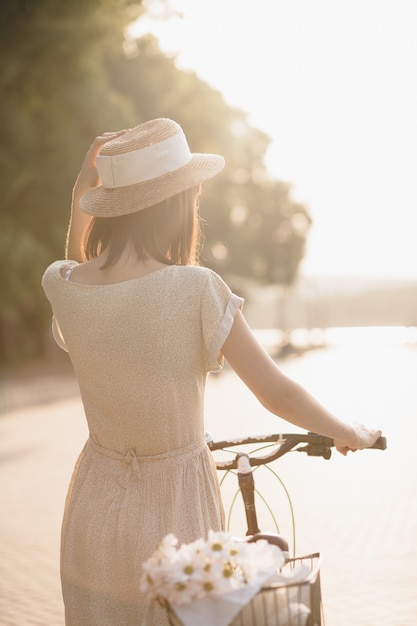 Junge Frau gegen Naturhintergrund mit Fahrrad