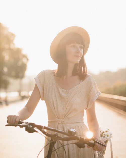 Junge Frau gegen Naturhintergrund mit Fahrrad