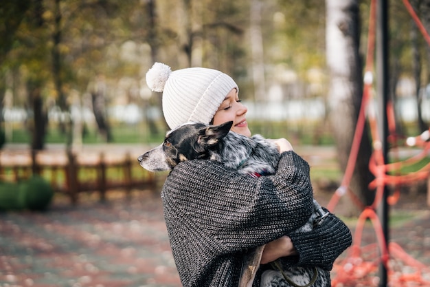 Junge Frau hält einen Hund in ihren Armen