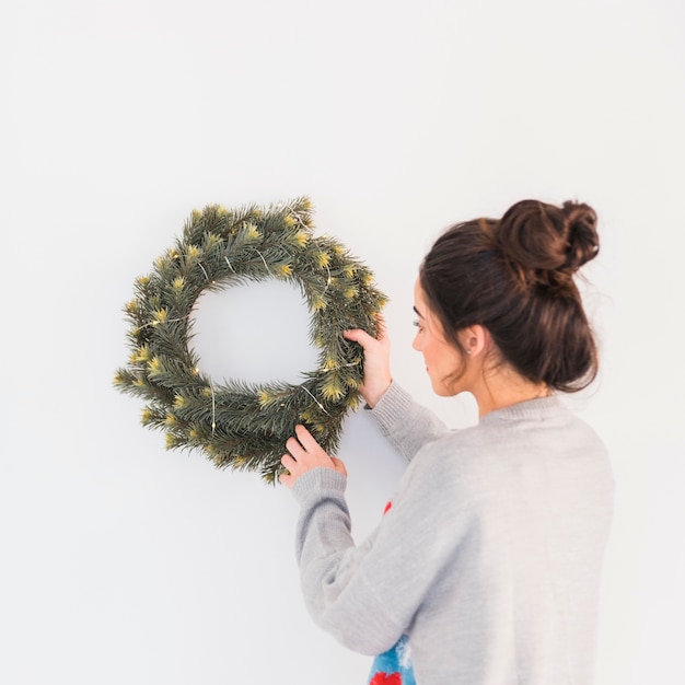 Junge Frau hängender Weihnachtskranz