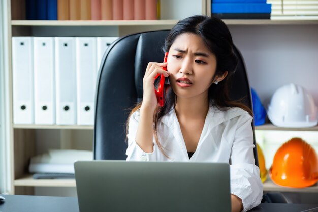 Junge Frau hat Problem beim Erledigen der Arbeit im Büro