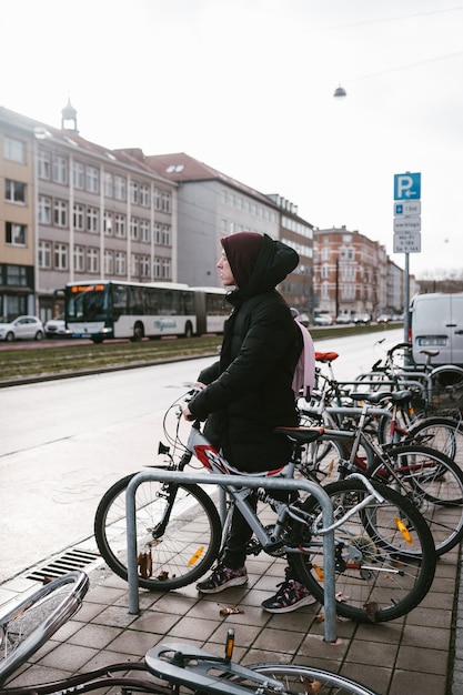 Junge Frau holt ihr Fahrrad vom Parkplatz ab