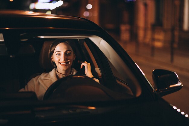 Junge Frau im Auto, das Sicherheitsgurt hält