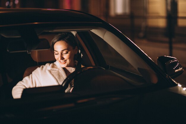 Junge Frau im Auto, das Sicherheitsgurt hält