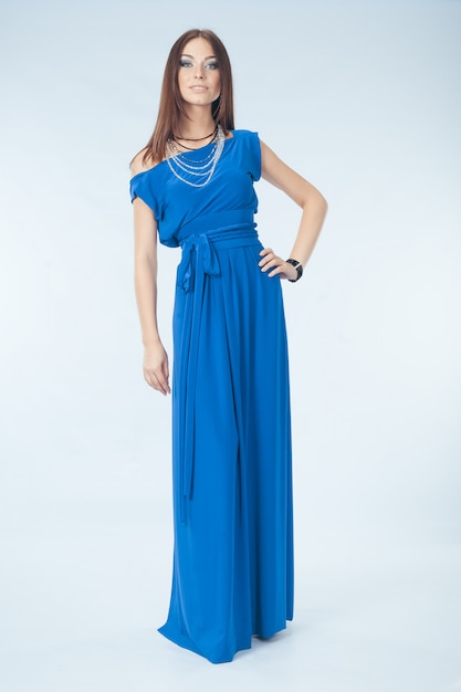 Junge Frau im blauen Kleid, das im Studio aufwirft