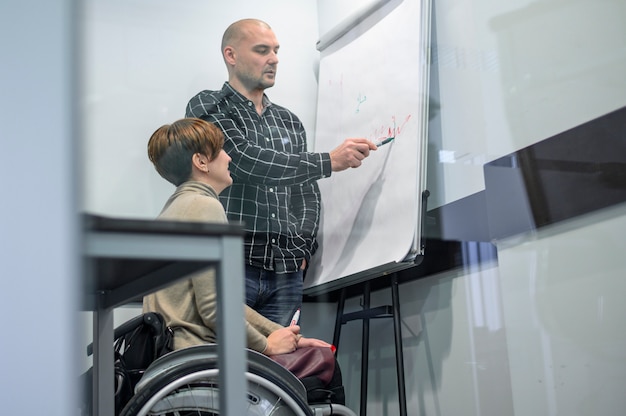 Kostenloses Foto junge frau im büro, die flipchart betrachtet