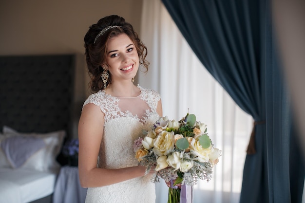 junge Frau im Hochzeitskleid drinnen