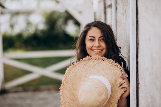 Junge Frau im Hut, der Kleid im Urlaub trägt