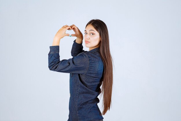 Junge Frau im Jeanshemd, das Liebe sendet