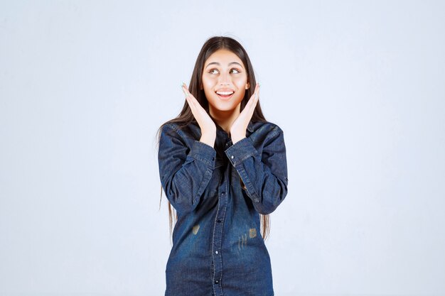 Junge Frau im Jeanshemd lächelnd und hübsches Gesicht machend