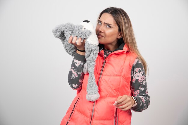 Junge Frau im lustigen Hut auf einer weißen Wand.