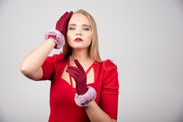 Junge Frau im roten Kleid, das zur Kamera aufwirft.