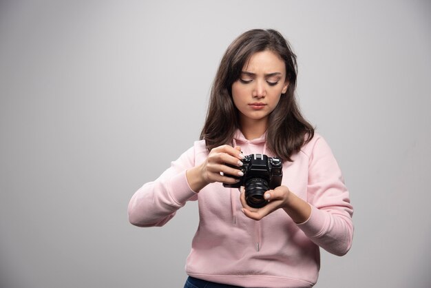 Junge Frau im Sweatshirt, das Kamera betrachtet.