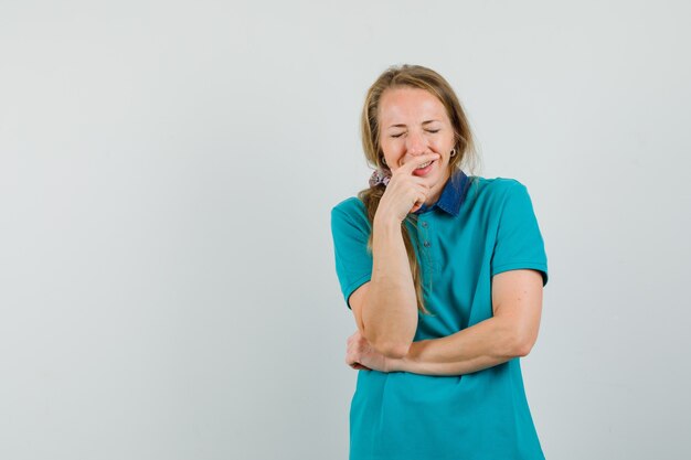 Junge Frau im T-Shirt lacht laut und sieht fröhlich aus