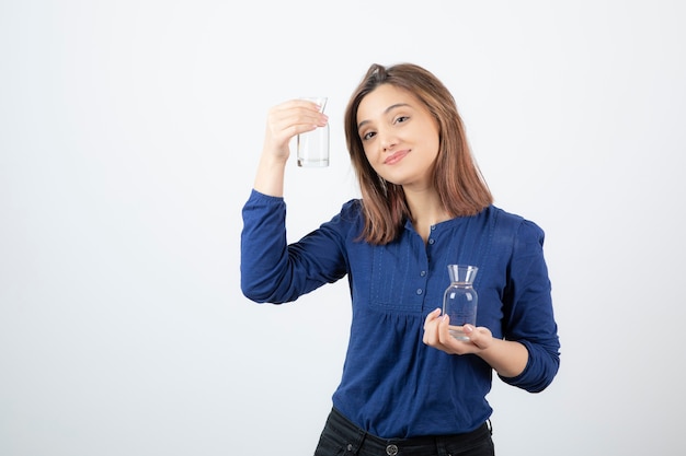 Junge Frau in der blauen Bluse, die Wasser in ihren Händen hält.