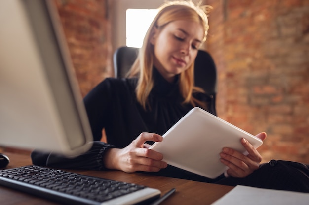 Junge Frau in der Geschäftskleidung, die im Büro arbeitet