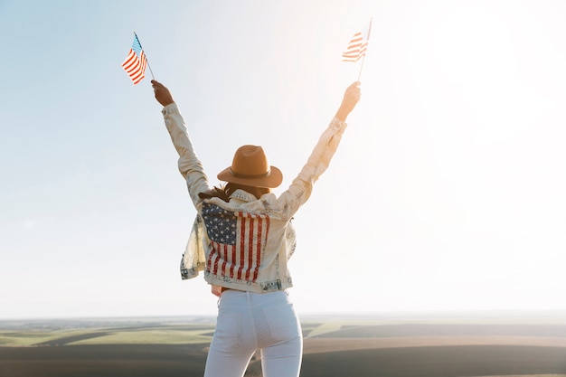 Junge Frau in der Jacke der amerikanischen Flagge auf Berg