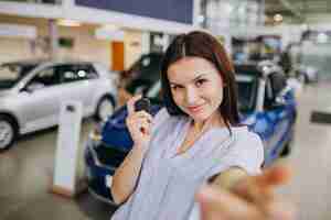 Kostenloses Foto junge frau in einem autosalon, der ein auto wählt