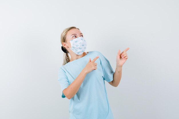 Junge Frau in einem blauen T-Shirt mit einer medizinischen Maske