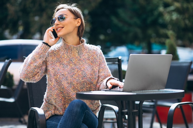 Junge Frau in einem Café unter Verwendung des Laptops