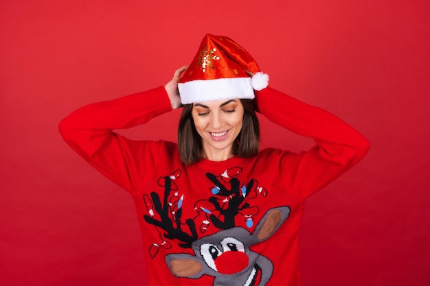 Kostenloses Foto junge frau in einem weihnachtspullover und einer weihnachtsmütze, die süß lächelt