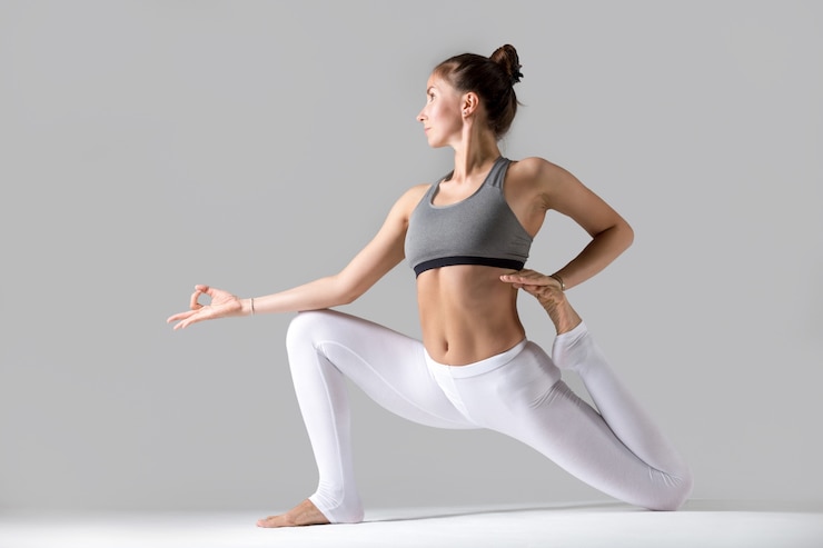 Kostenlose Foto junge frau in eka pada rajakapotasana pose, grau studio hintergrund