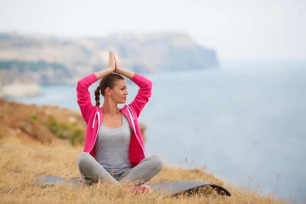 junge Frau in Sportkleidung beim Yoga im Freien