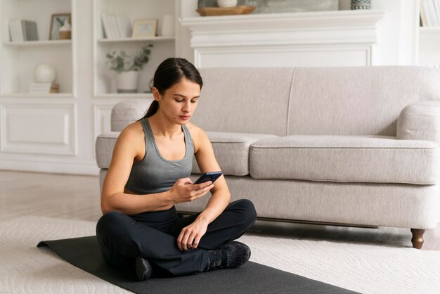 Junge Frau in Sportkleidung, die zu Hause trainiert