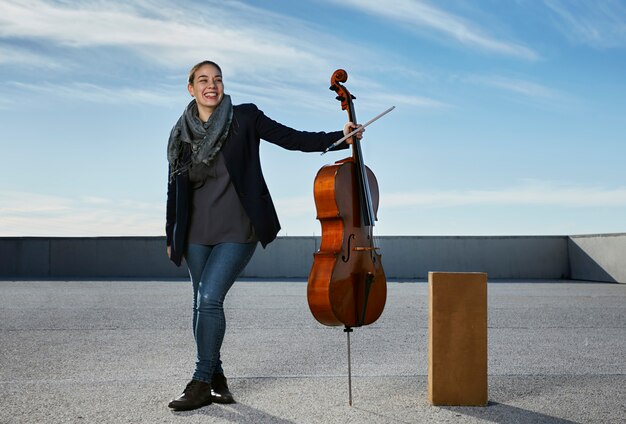 junge Frau lacht glücklich mit ihrem Instrument