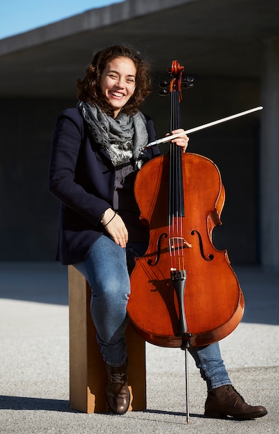 junge Frau lacht glücklich mit ihrem Instrument