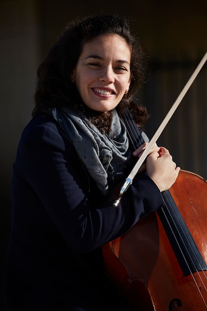 junge Frau lacht glücklich mit ihrem Instrument