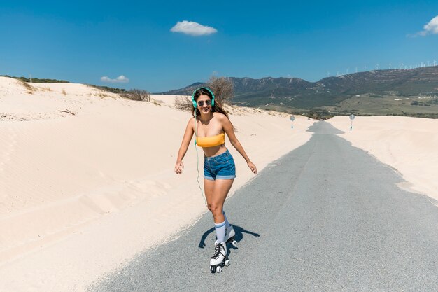 Junge Frau läuft auf Rollen nahe Strand