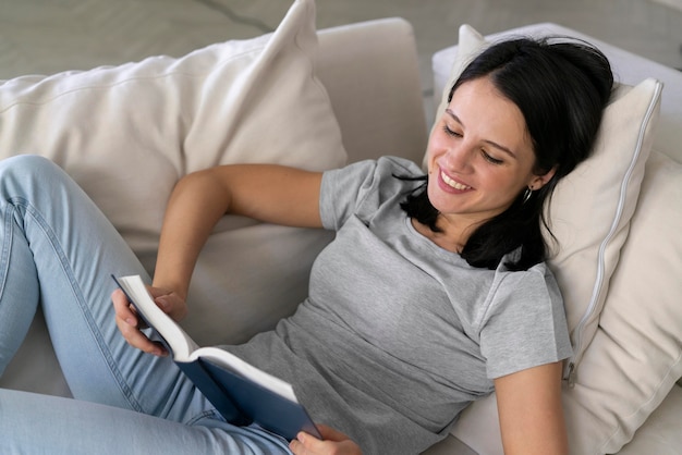 Junge Frau liest zu Hause aus einem Buch