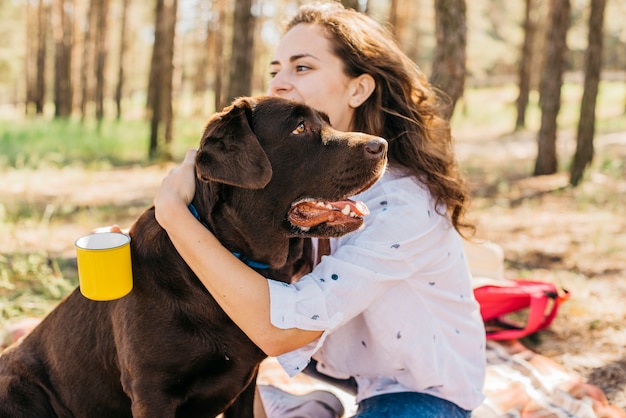 Junge Frau macht ein Picknick mit ihrem Hund