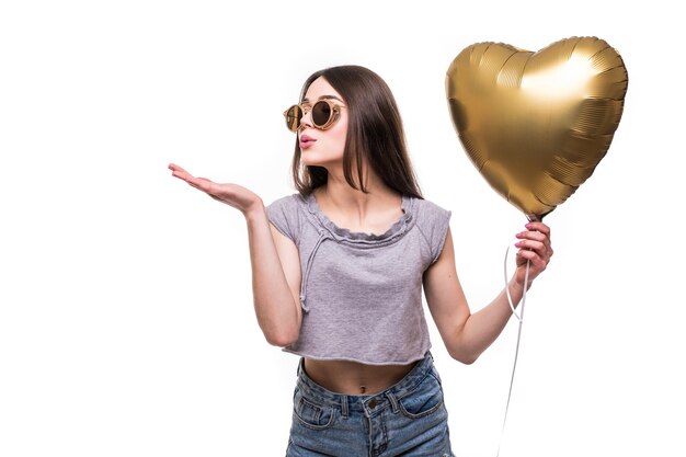 Junge Frau macht einen Luftkuss mit einem Herzballon in Form eines Herzens