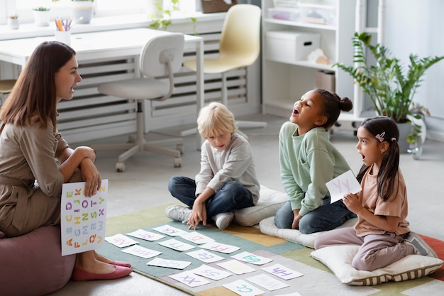 Junge Frau macht Sprachtherapie mit Kindern