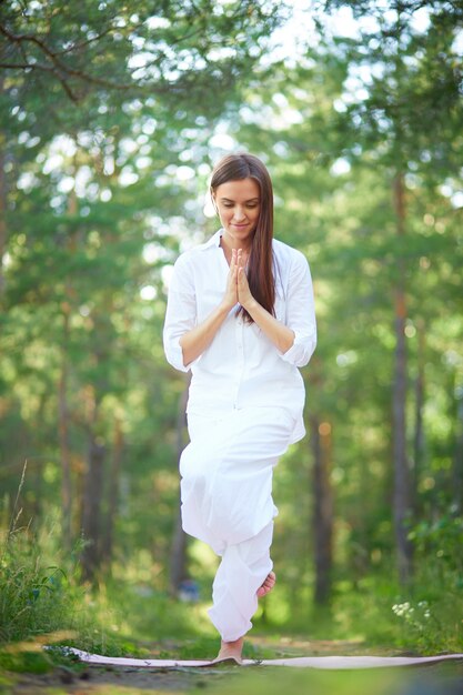 Junge Frau macht Yoga-Kurs im Park