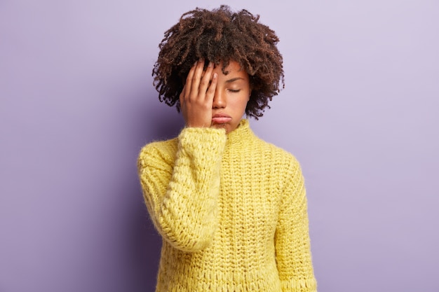 Kostenloses Foto junge frau mit afro-haarschnitt, der gelben pullover trägt