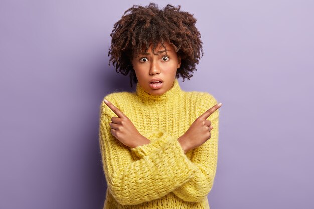 Junge Frau mit Afro-Haarschnitt, der gelben Pullover trägt