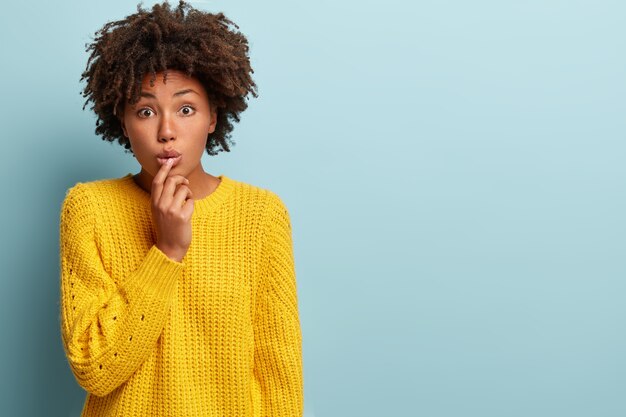 Junge Frau mit Afro-Haarschnitt, der Pullover trägt