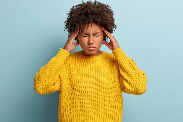 Junge Frau mit Afro-Haarschnitt, der Pullover trägt