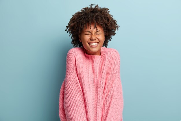 Junge Frau mit Afro-Haarschnitt, der Pullover trägt