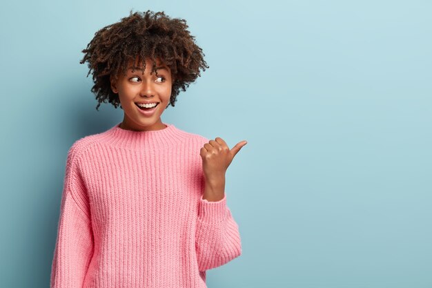 Junge Frau mit Afro-Haarschnitt, der Pullover trägt