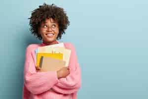 Kostenloses Foto junge frau mit afro-haarschnitt, der rosa pullover trägt