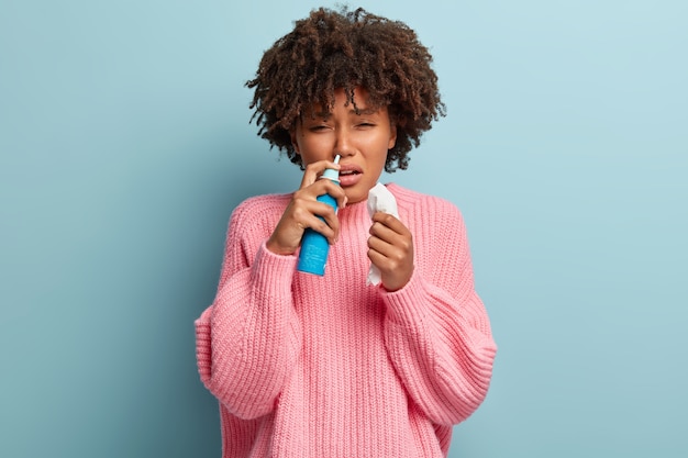 Kostenloses Foto junge frau mit afro-haarschnitt, der rosa pullover trägt