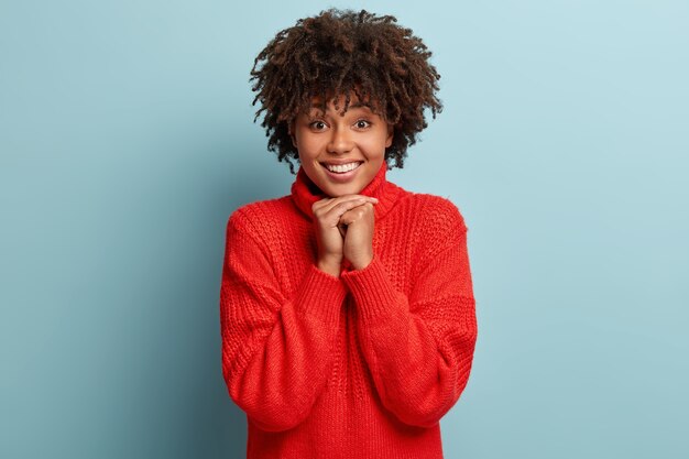 Junge Frau mit Afro-Haarschnitt, die roten Pullover trägt