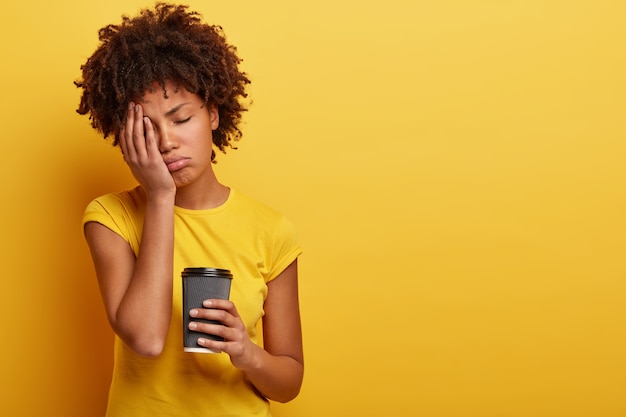 Junge Frau mit Afro-Haarschnitt, die Tasse Kaffee hält