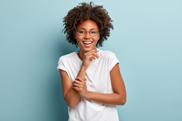 Junge Frau mit Afro-Haarschnitt, die weißes T-Shirt trägt